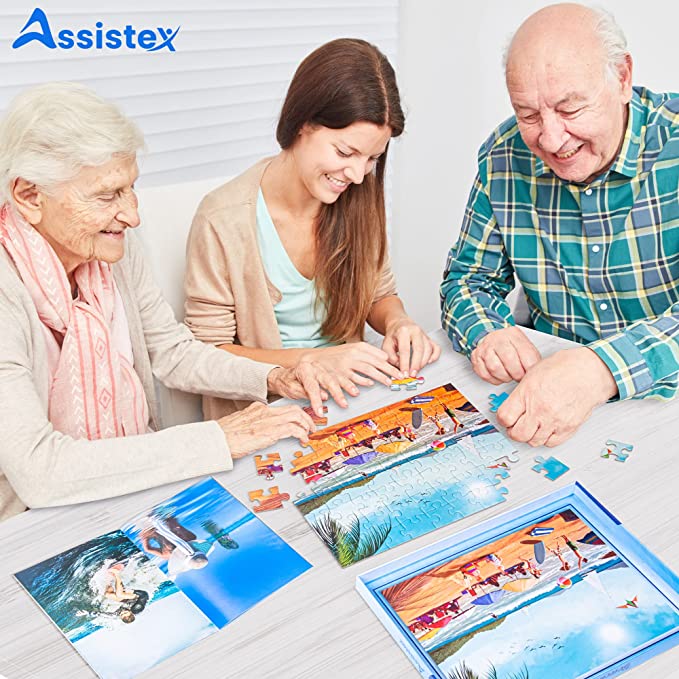 Three adults assembling the Beach Fun jigsaw puzzle together at a table, with the puzzle box and picture book nearby — Assistex via EOWD Autism Living