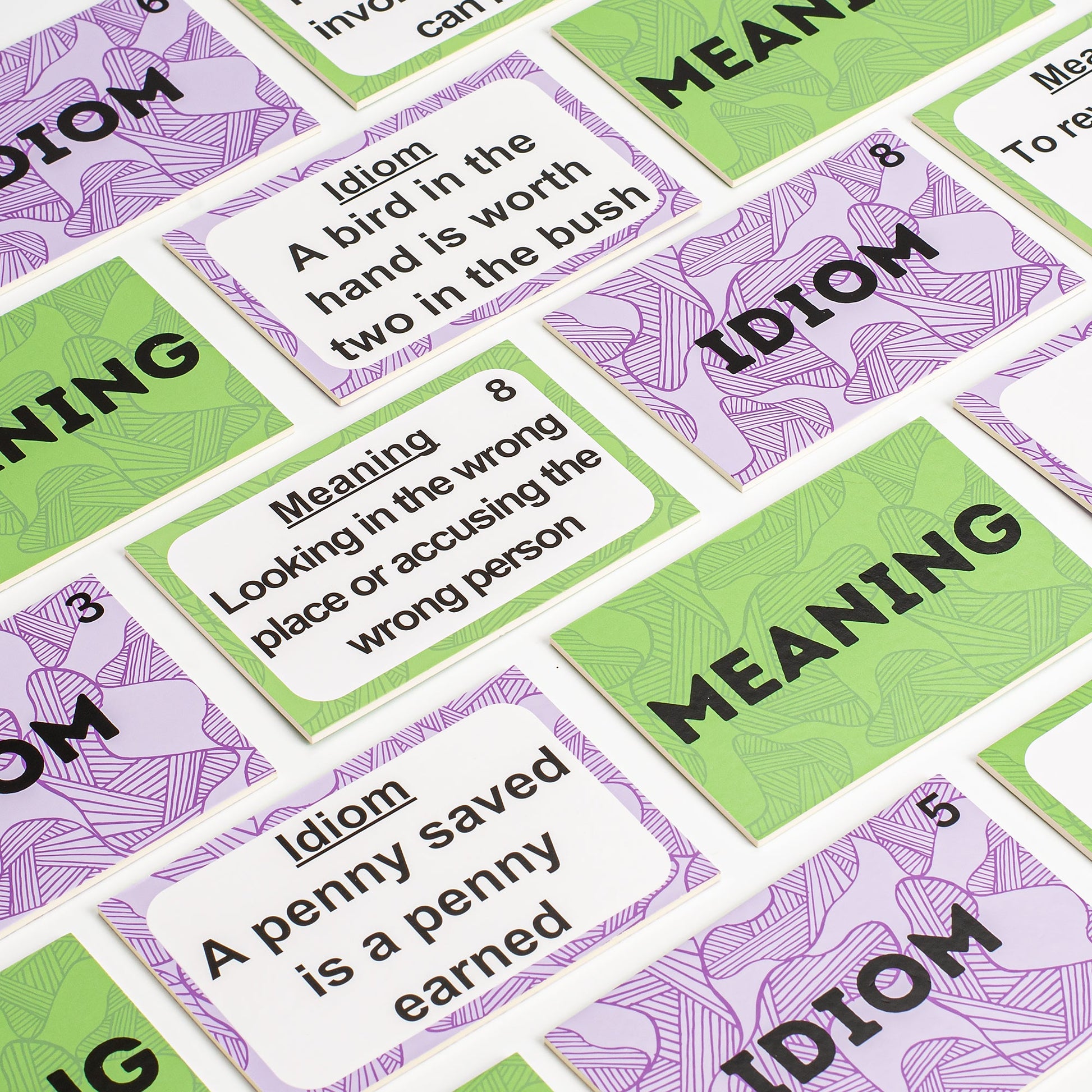 Flat lay of Assistex lyric and idiom matching card game cards spread on white background — Assistex via EOWD Autism Living