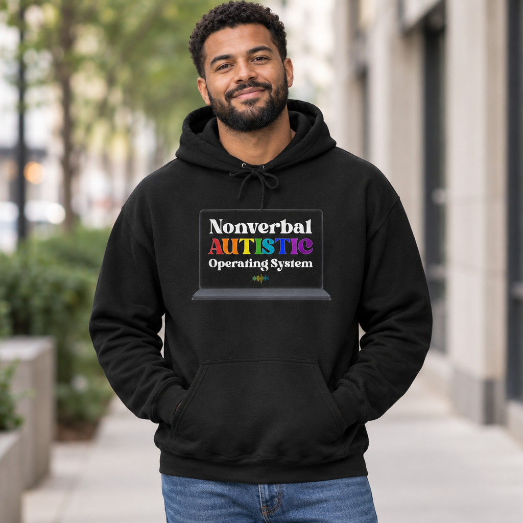 Adult man wearing a black pullover hoodie with the bold rainbow “Nonverbal AUTISTIC Operating System” laptop graphic on a city sidewalk — EOWD Autism Living