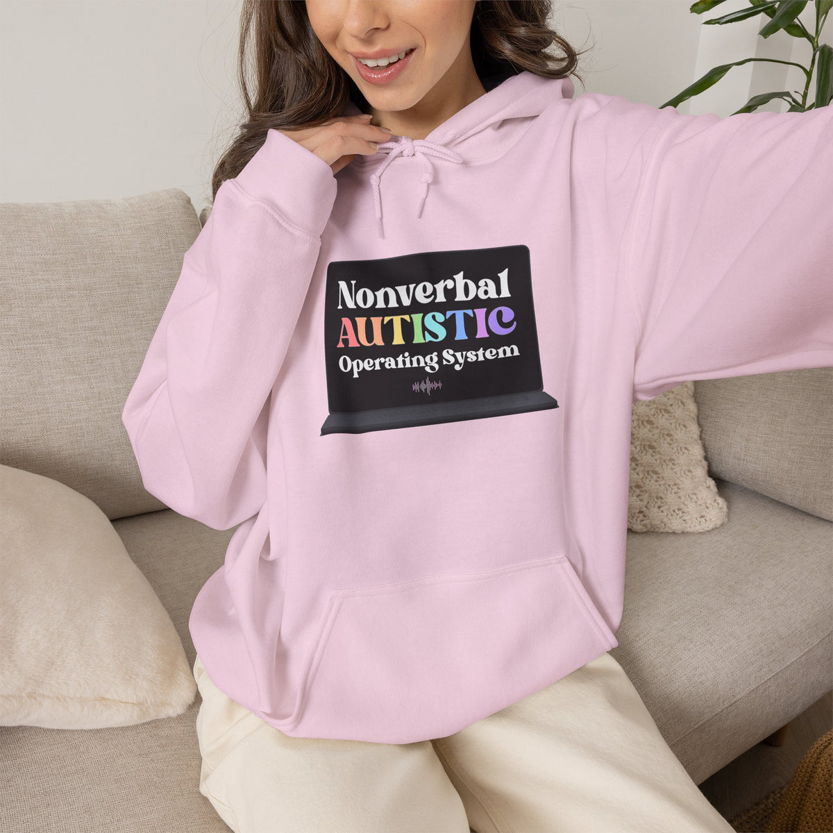 Person wearing a light pink pullover hoodie with a small rectangular graphic centered on the chest — EOWD Autism Living
