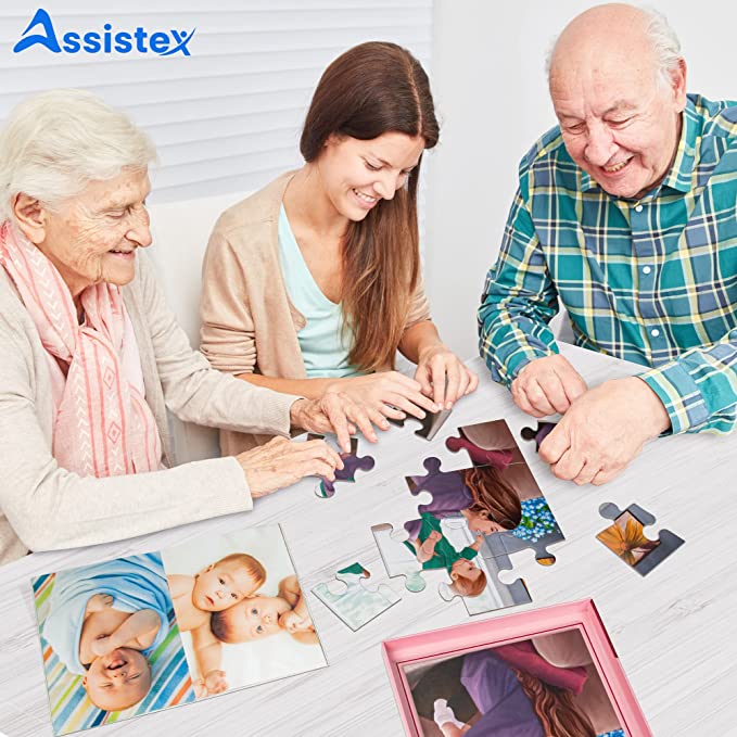 Senior woman and caregiver working a large piece jigsaw puzzle together at a table — Assistex via EOWD Autism Living