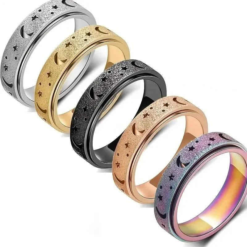 Five stainless steel rotatable moon and star fidget rings fanned on white background — silver, gold, black, rose gold, and multicolor finishes shown — DailySale via EOWD Autism Living